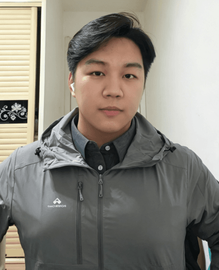 穿着灰色冲锋衣，背景是家里衣柜